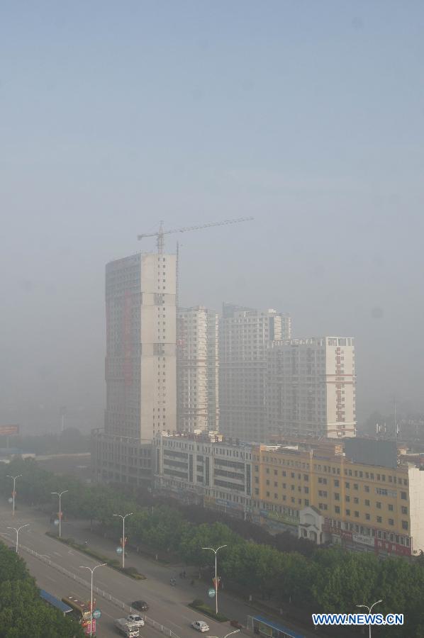 Buildings are shrouded in heavy fog in Liaocheng City, east China's Shandong Province, May 10, 2013. (Xinhua/Zhang Xianju)