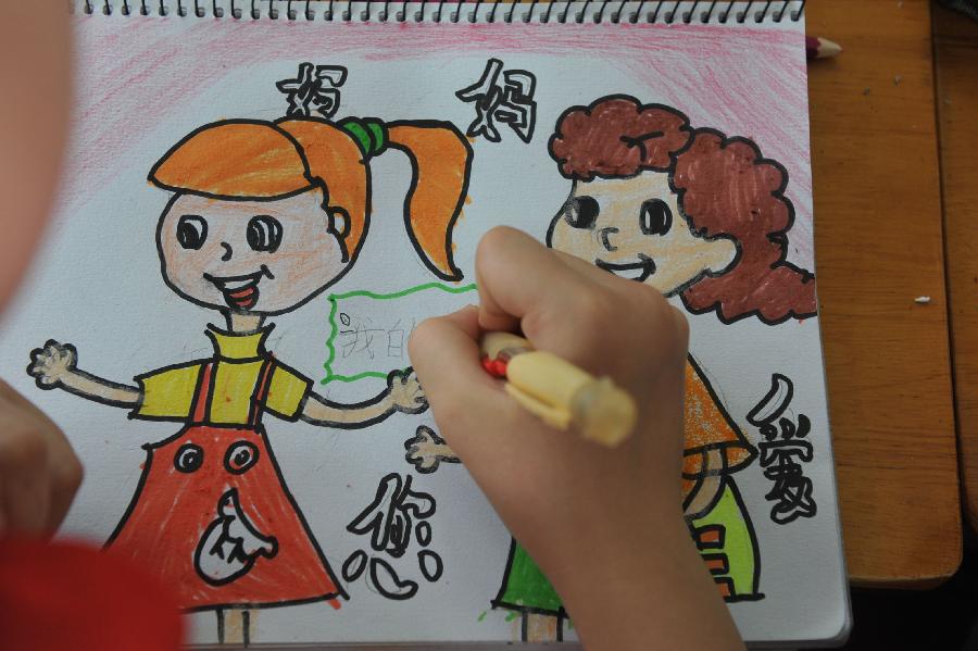 A pupil draws a picture for her mother as a gift ahead of the Mother's Day in Lin'an City, east China's Zhejiang Province, May 9, 2013. (Xinhua/Hu Jianhuan) 