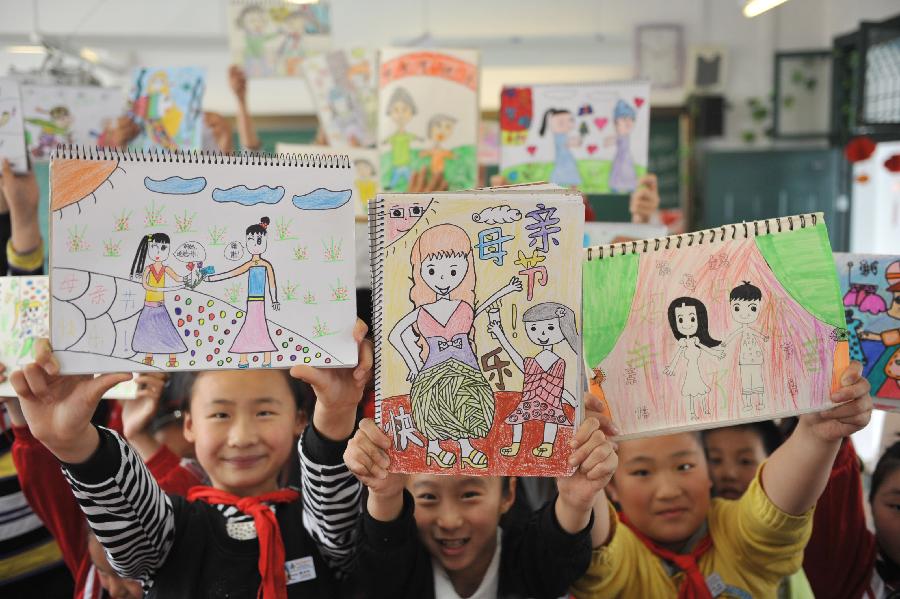 Pupils show their paintings as gifts for their mothers ahead of the Mother's Day in Lin'an City, east China's Zhejiang Province, May 9, 2013. (Xinhua/Hu Jianhuan) 