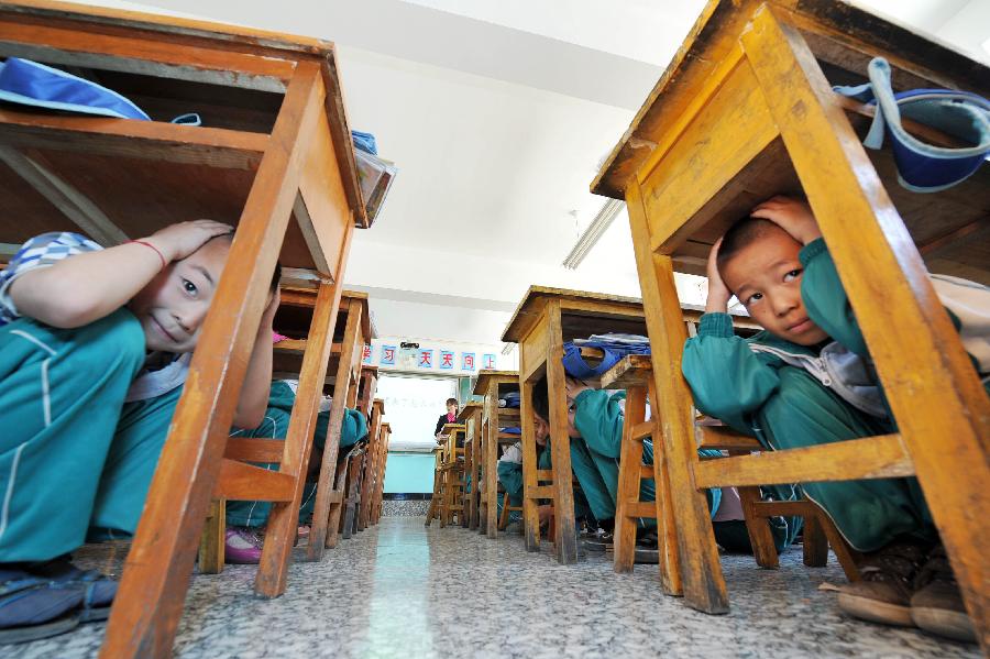 Pupils take part in an earthquake drill in Helan County of Yinchuan City, capital of northwest China's Ningxia Hui Autonomous Region, May 10, 2013, two day ahead of the Disaster Prevention and Reduction Day. The Disaster Prevention and Reduction Day was set in 2009, after a devastating earthquake hit Sichuan and neighboring Gansu and Shaanxi provinces on May 12, 2008, leaving 87,000 people dead or missing. (Xinhua/Peng Zhaozhi) 