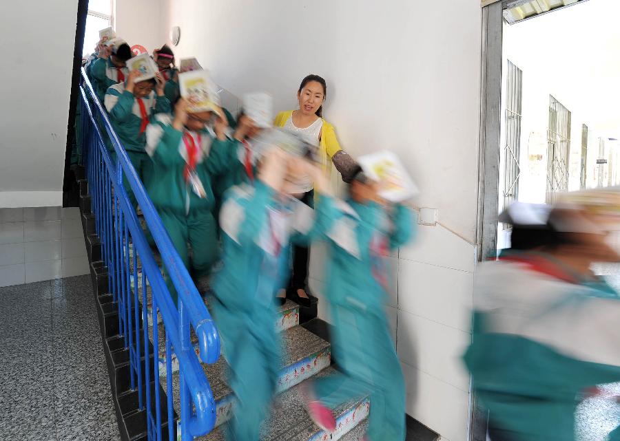 Pupils take part in an earthquake drill in Helan County of Yinchuan City, capital of northwest China's Ningxia Hui Autonomous Region, May 10, 2013, two day ahead of the Disaster Prevention and Reduction Day. The Disaster Prevention and Reduction Day was set in 2009, after a devastating earthquake hit Sichuan and neighboring Gansu and Shaanxi provinces on May 12, 2008, leaving 87,000 people dead or missing. (Xinhua/Peng Zhaozhi) 