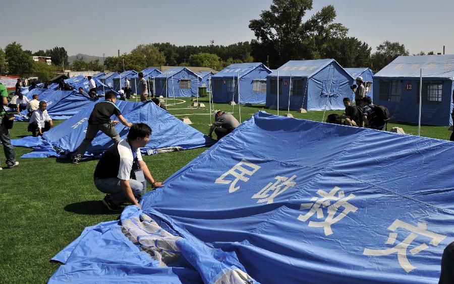 Rescuers put up tents during a disaster relief drill in Beijing, capital of China, May 10, 2013, two day ahead of the Disaster Prevention and Reduction Day. The Disaster Prevention and Reduction Day was set in 2009, after a devastating earthquake hit Sichuan and neighboring Gansu and Shaanxi provinces on May 12, 2008, leaving 87,000 people dead or missing. (Xinhua/Li Xin) 