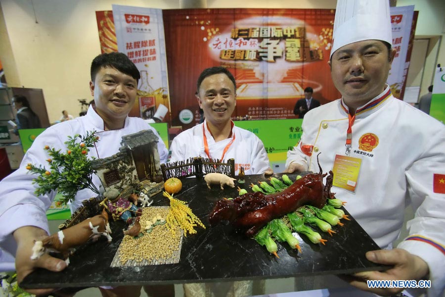 Cooks show a dish at a cooking contest during the 8th China (Beijing) Catering & Food Fair in Beijing, capital of China, May 9, 2013. (Xinhua)