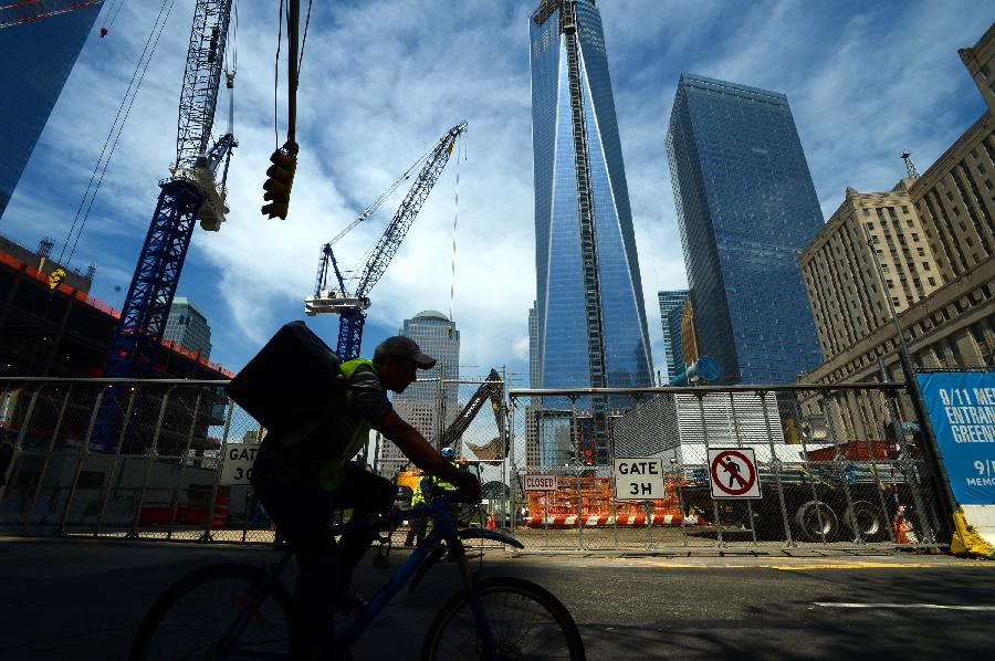 A man rides by One World Trade Center (WTC) in New York, May 10, 2013. Workers have installed the final sections of the silver spire atop WTC on Friday, which brings the iconic New York City structure to its full, symbolic height of 1,776 feet (541 meters). (Xinhua/Wang Lei) 