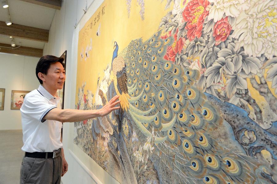 Chinese painter Yuan Xiang introduces his work to visitors in the Yuan Xiang Traditional Chinese Realistic Painting Exhibition at the Ueno Royal Museum in Tokyo, Japan, May 10, 2013. Yuan Xiang brought more than 20 traditional Chinese realistic paintings to his exhibition at the Ueno Royal Museum. (Xinhua/Ma Ping)