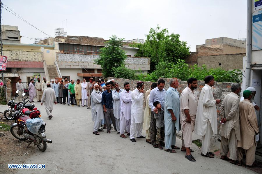 Pakistanis queue to cast their votes at a polling station in Rawalpindi, Pakistan, May 11, 2013. Pakistanis began voting on Saturday morning in a one-day general election to elect a new government for the next five years with hopes of a positive change and end to the years of terrorism in the country. (Xinhua/Ahmad Kamal) 