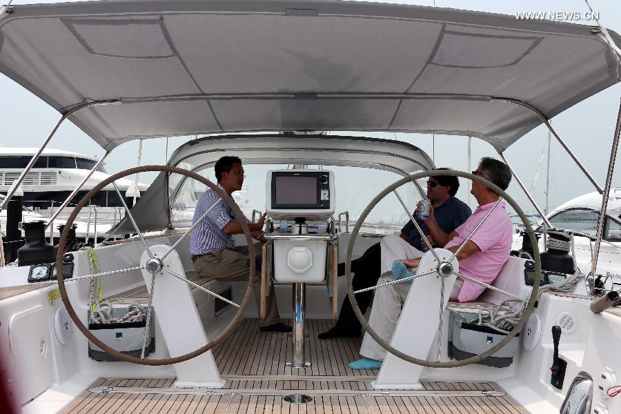 Photo taken on May 11, 2013 shows people talking on a sailing boat at an exhibition held by the Gold Coast Yacht Country Club in Hong Kong, south China. The exhibition has attracted 70 exhibitors around the world with their luxurious yachts as well as a fancy lifestyle at sea. (Xinhua/Li Peng) 