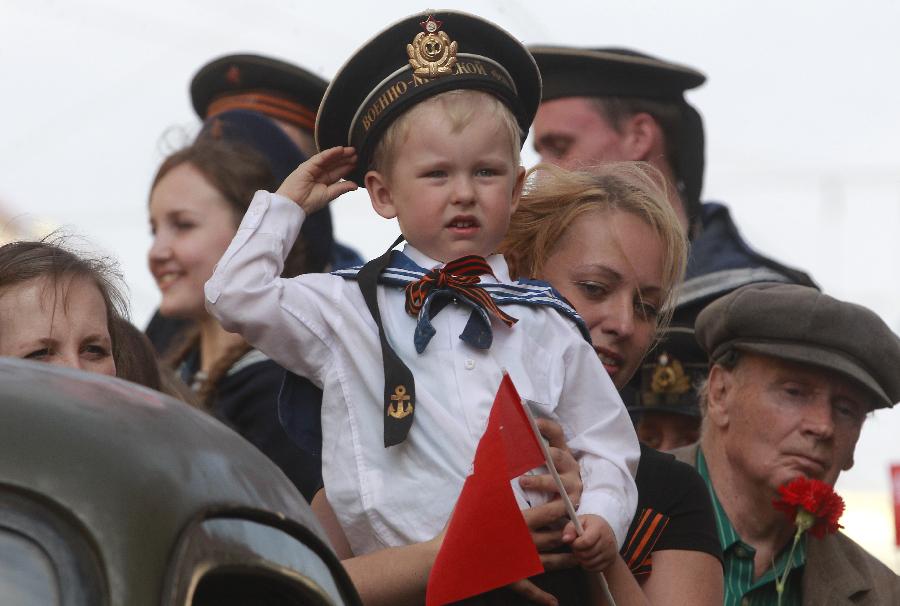 A child wearing Soviet Navy style uniform salutes during celebration of the Victory Day in St.Petersburg, Russia, May 9, 2013. Russia is celebrating the anniversary of victory over Germany in WWII. (Xinhua/AP Photo)