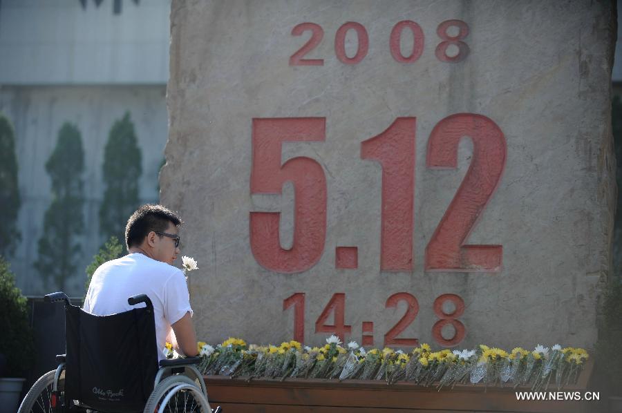 A young man who lost his legs in the earthquake five years ago mourns for victims of the quake in front of a monument in Beichuan, southwest China's Sichuan Province, May 12, 2013. Mourners gathered on Sunday in Beichuan, one of the worst hit regions in the Wenchuan Earthquake, to mark the fifth anniversary of the deadly earthquake on May 12, 2008 in which more than 80,000 people were killed or missing. (Xinhua/Xue Yubin) 