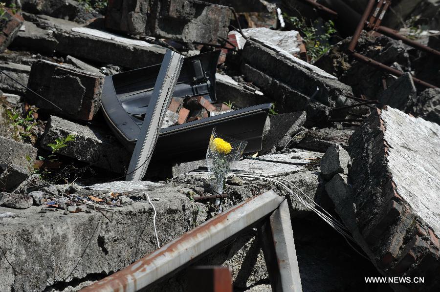 A flower is put among ruins created by the quake in Beichuan, southwest China's Sichuan Province, May 12, 2013. Mourners gathered on Sunday in Beichuan, one of the worst hit regions in the Wenchuan Earthquake, to mark the fifth anniversary of the deadly earthquake on May 12, 2008 in which more than 80,000 people were killed or missing. (Xinhua/Xue Yubin) 