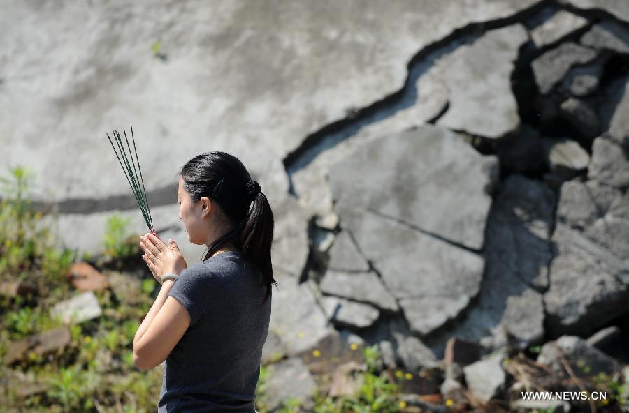 A woman mourns for victims of the quake in Beichuan, southwest China's Sichuan Province, May 12, 2013. Mourners gathered on Sunday in Beichuan, one of the worst hit regions in the Wenchuan Earthquake, to mark the fifth anniversary of the deadly earthquake on May 12, 2008 in which more than 80,000 people were killed or missing. (Xinhua/Xue Yubin) 