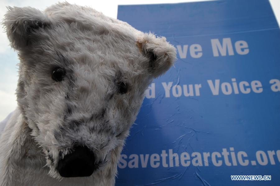 An activist in polar bear costume stands next to a placard during an Arctic-saving campaign in Jakarta, Indonesia, May 12, 2013. The reduction in Arctic summer ice cover registered a record low of 3.4 million square kilometers in 2012, which was 18 percent below the previous recorded minimum in 2007 and 50 percent below the average in the 1980s and 1990s, stated the UN Environment Program (UNEP). (Xinhua/Veri Sanovri)