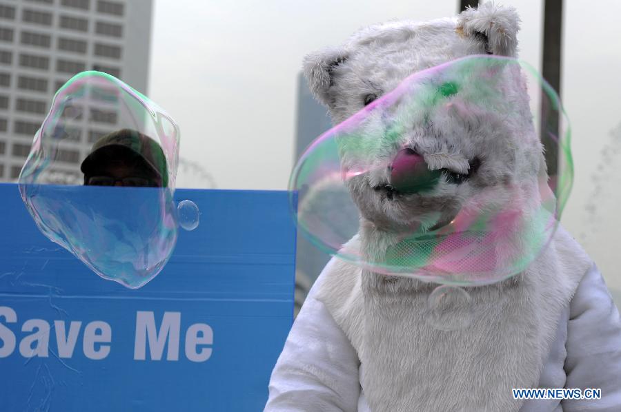 An activist in polar bear costume stands next to a placard during an Arctic-saving campaign in Jakarta, Indonesia, May 12, 2013. The reduction in Arctic summer ice cover registered a record low of 3.4 million square kilometers in 2012, which was 18 percent below the previous recorded minimum in 2007 and 50 percent below the average in the 1980s and 1990s, stated the UN Environment Program (UNEP). (Xinhua/Veri Sanovri) 