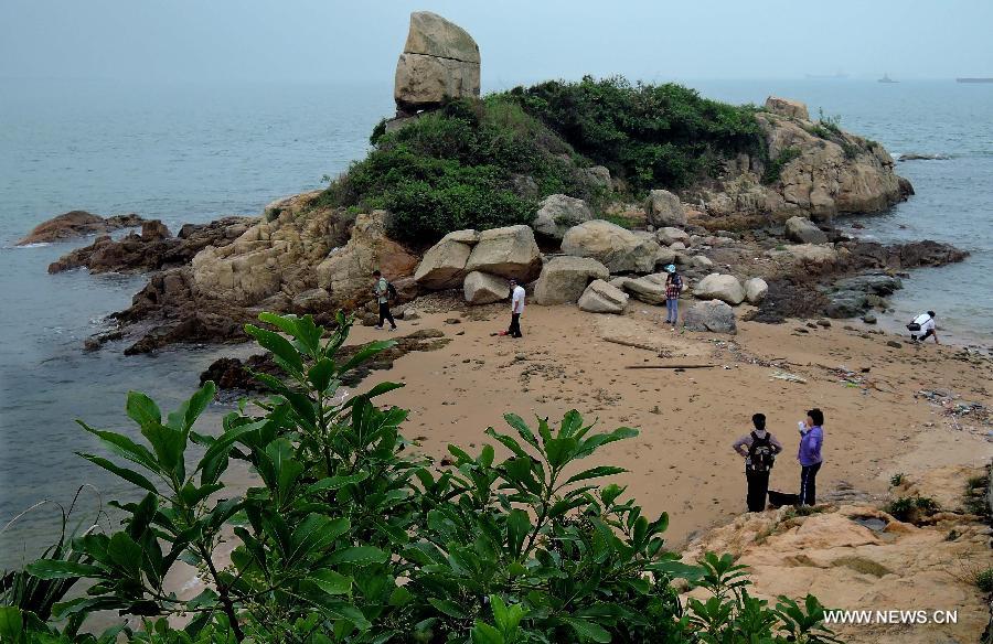 Visitors tour at the Ping Chau Island in south China's Hong Kong, May 12, 2013. Ping Chau, also named Tung Ping Chau, lies in the northeast corner of Hong Kong and is part of the Hong Kong Geopark. The island is home to shale rocks in various shapes which makes it a popular tourist attraction. (Xinhua/Chen Xiaowei)