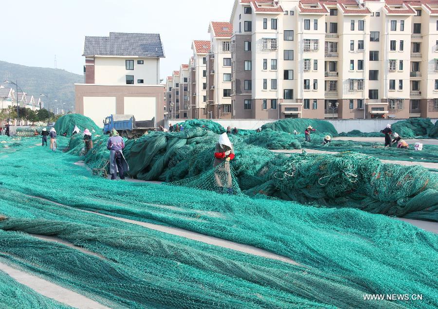 Fishermen take advantage of fishing moratorium to mend fishing nets in Qushan Town of Daishan County in Zhoushan City, east China's Zhejiang Province, May 12, 2013. The East China Sea entered a fishing ban period in an effort to protect the area's fishery resources from May 1. Light seiners will see the fishing moratorum end on July 1 while those using boat to cast nets to fish will not be allowed to restart fishing until Sept. 16. (Xinhua/Suo Xianglu)