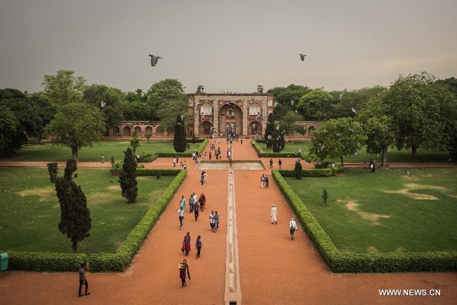 Tourists visit the gardens at Humayun's Tomb in New Delhi, capital of India, May 12, 2013. Humayun's Tomb, located in east New Delhi, was built in 1569 to 1570 by Humayun's widow. As a precursor to the Taj Mahal, it stands on a platform of 12,000 square meters and reaches a height of 47 meters. The earliest example of the Persian influence in Indian architecture, the tomb itself is in the center of a large garden, surrounded by 12 hectares of gardens with pools joined by channels. The tomb brought Persian style to Delhi, but the two-tone combination of red sandstone and white marble is local, which shows the merging of different cultures. Humayun's Tomb was inscribed on the World Heritage List by the United Nations Educational, Scientific and Cultural Organization in 1993. (Xinhua/Zheng Huansong)