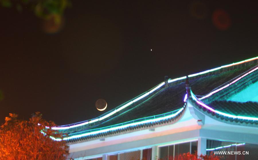 Picture taken on May 12, 2013 shows the planet Jupiter (R) next to the moon in the sky over Duchang County, east China's Jiangxi Province. The astronomical phenomena is rare to see when the Jupiter moves closest to the moon. (Xinhua/Fu Jianbin) 