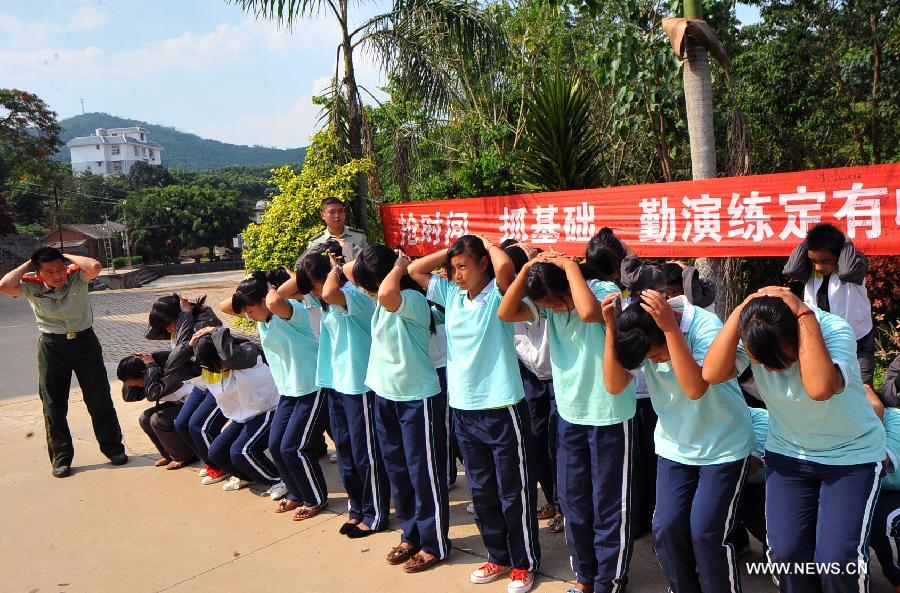 Middle school students participate in an earthquake relief drill in Jinghong City of Xishuangbanna Dai Autonomous Region, southwest China's Yunnan Province, May 12, 2013, the country's Disaster Prevention and Reduction Day. (Xinhua/Chen Haining) 