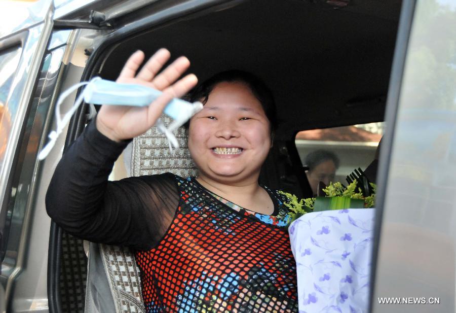 The 31-year-old H7N9 bird flu patient surnamed Xu waves to doctors and nurses as she leaves the hospital after full recovery in Nanchang, capital of east China's Jiangxi Province, May 13, 2013. Xu was the second infections with the H7N9 bird flu virus to be cured in the province. (Xinhua/Chen Zixia)