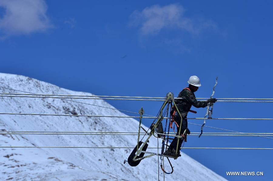 A worker fixes spacers for electric transmission wires in Yushu, northwest China's Qinghai Province, May 11, 2013. A power grid construction came to the end in Yushu recently which could ease local electricity shortage. The 330-kv project includes 800-km-long wires and substations, and a test run will start next month. Yushu had its isolated grid severely damaged in the magnitude 7.1 earthquake in April 2010, claiming 2,698 lives and injuring over 12,000. (Xinhua/Wang Bo)  