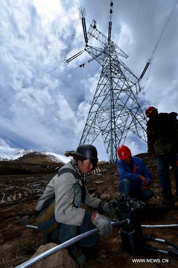 Workers connect wires for a power grid project in Yushu, northwest China's Qinghai Province, May 12, 2013. The power grid construction came to the end in Yushu recently which could ease local electricity shortage. The 330-kv project includes 800-km-long wires and substations, and a test run will start next month. Yushu had its isolated grid severely damaged in the magnitude 7.1 earthquake in April 2010, claiming 2,698 lives and injuring over 12,000. (Xinhua/Wang Bo)