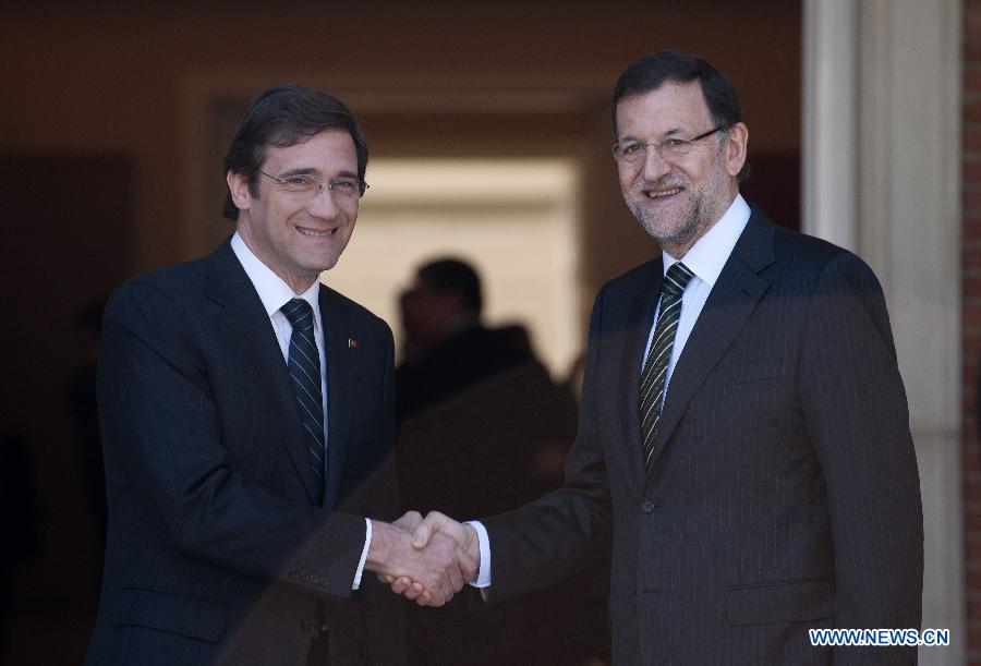 Spanish Prime Minister Mariano Rajoy (R) shakes hands with Portuguese Prime Minister Pedro Passos Coelho during their one-day summit meeting in Madrid, Spain, on May 13, 2013. (Xinhua/Xie Haining)