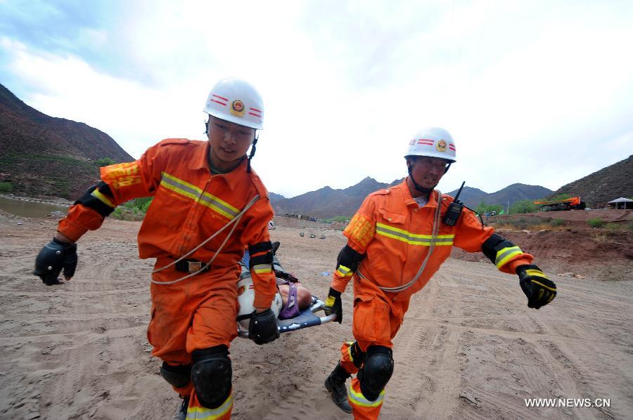 Fire fighters carry "an injured person" during an earthquake drill in Qamdo, southwest China's Tibet Autonomous Region, May 13, 2013. The drill was held by local fire fighting department to test and evaluate their response and rescue ability in the event of disasters. (Xinhua/Wen Tao)