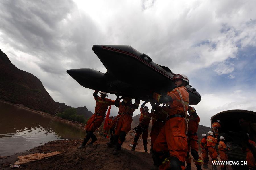 Fire fighters carry a rubber raft during an earthquake drill in Qamdo, southwest China's Tibet Autonomous Region, May 13, 2013. The drill was held by local fire fighting department to test and evaluate their response and rescue ability in the event of disasters. (Xinhua/Wen Tao)  
