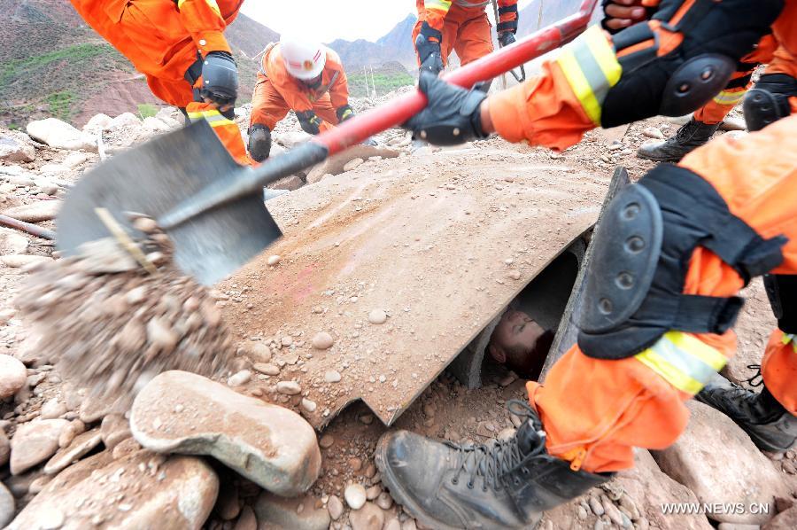 Fire fighters try to rescue a man stranded in ruins during an earthquake drill in Qamdo, southwest China's Tibet Autonomous Region, May 13, 2013. The drill was held by local fire fighting department to test and evaluate their response and rescue ability in the event of disasters. (Xinhua/Wen Tao) 