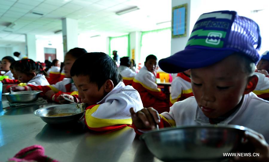 Orphan students have dinner at the Bayi Orphan School in Yushu Tibet Autonomous Prefecture in northwest China's Qinghai Province, May 13, 2013. The school is now a home of 323 orphan students who are instructed and cared by 57 teachers. (Xinhua/Wang Bo)