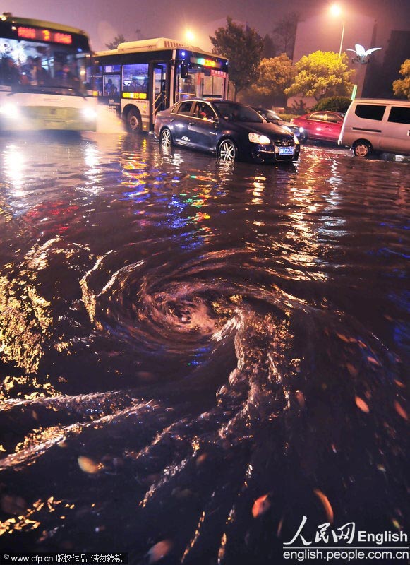 A traffic accident is caused by the rainstorm that hit Changsha at night of March 22, 2013. Passengers had to get off the cars and wait for water to subside.  (Photo/Xinhua)