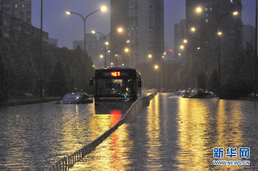 Vehicles are submerged in rain water in Beijing on July 21, 2012. A sudden downpour disrupted traffic in many areas of the city. (Photo/Xinhua)