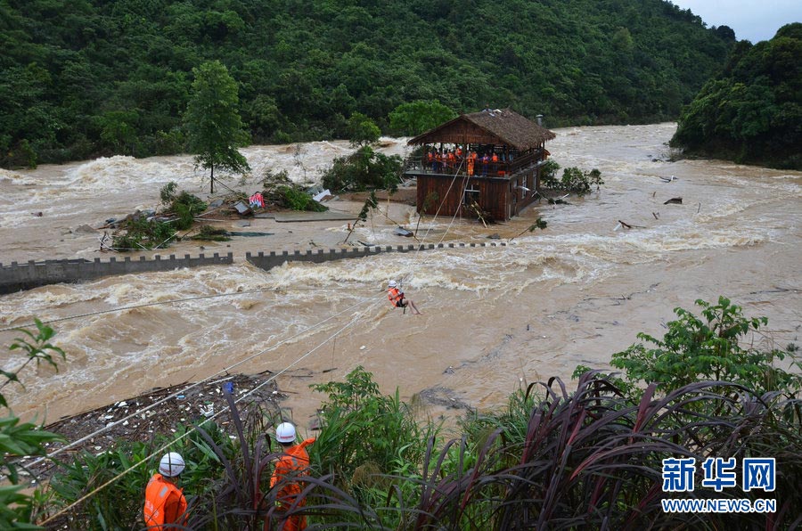 A rainstorm hits in Fangchenggan, south China's Guangxi Zhuang Autonomous Region, May 6, 2012. Photo shows local fire fighters rescuing 14 tourists who were trapped in flood. (Photo/Xinhua)