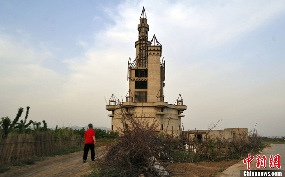 A resident living nearby walks past an abandoned castle standing in the Wonderland Amusement Park, May 12, Beijing’s Changping district. (CNS/Yang Yang)