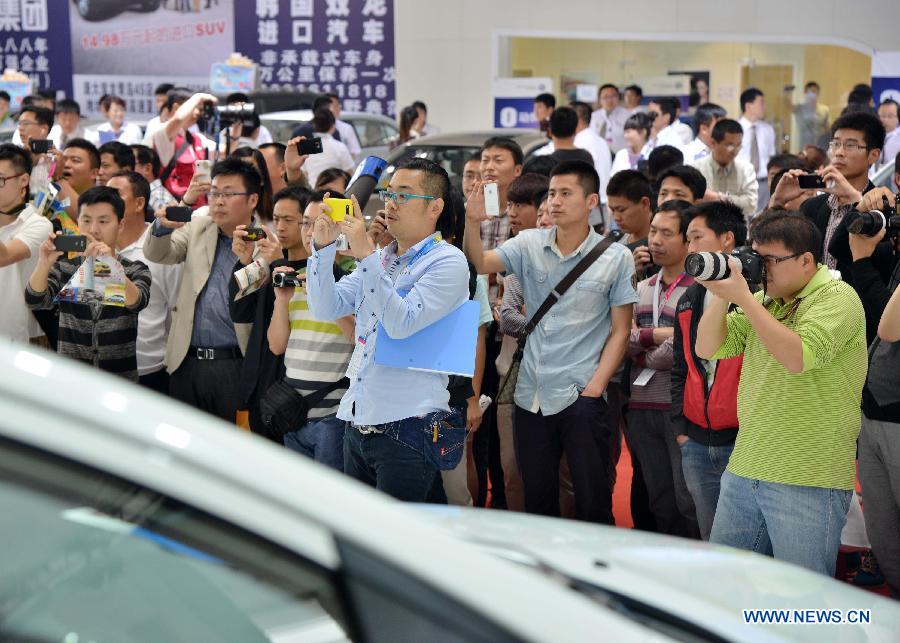 People take pictures at the 2013 Qingdao International Auto Show in Qingdao, a coastal city in east China's Shandong Province, May 14, 2013. The six-day auto show kicked off on Tuesday. (Xinhua/Li Ziheng)