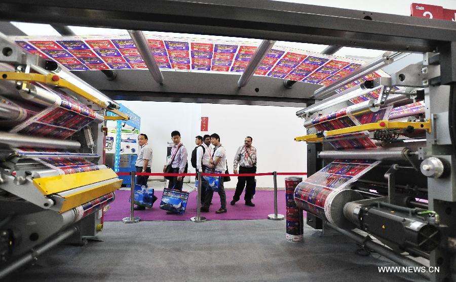 Visitors watch an environment-friendly printing machine during the 8th Beijing International Printing Technology Exhibition in Beijing, capital of China, May 14, 2013. The five-day exhibition opened at New China International Center in Beijing Tuesday. (Xinhua/Xiao Xiao) 