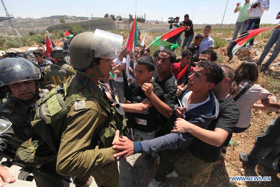 Palestinian protesters confront Israeli soldiers during clashes after a rally marking Nakba Day in the West Bank village of Al-Khader, near Bethlehem, May 14, 2013. Palestinians are preparing to mark Nakba Day on May 15, the annual day of commemoration of the displacement of Palestinians that followed the Israeli Declaration of Independence in 1984. (Xinhua/Luay Sababa)