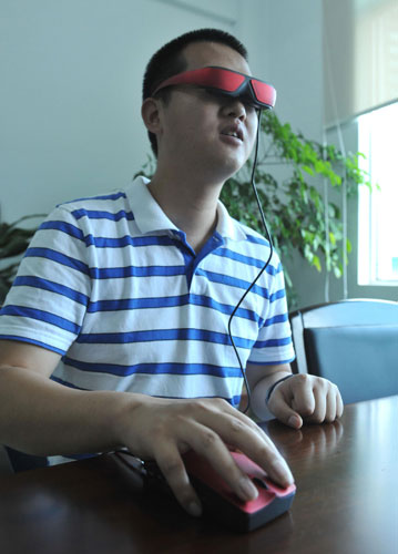 A man tries out an eye-book, a wearable computer developed by Yunnan North OLiGHTEK Opto-Electronic Technology Co, which focuses on micro display development, May 9, 2013. [Photo/Xinhua]