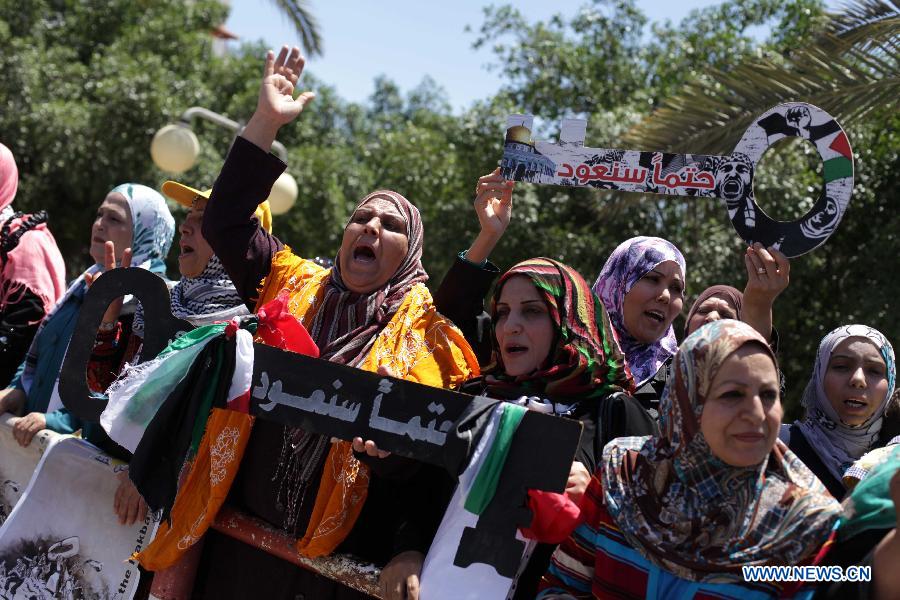 Palestinian protesters take part in a rally ahead of Nakba Day near the border between Israel and the southern Gaza Strip city of Khan Younis on May 14, 2013. Palestinians are preparing to mark Nakba Day on May 15, which marked thousands of Palestinians were forced to leave their homes during the Arab-Israeli war in 1948. (Xinhua/Khaled Omar)