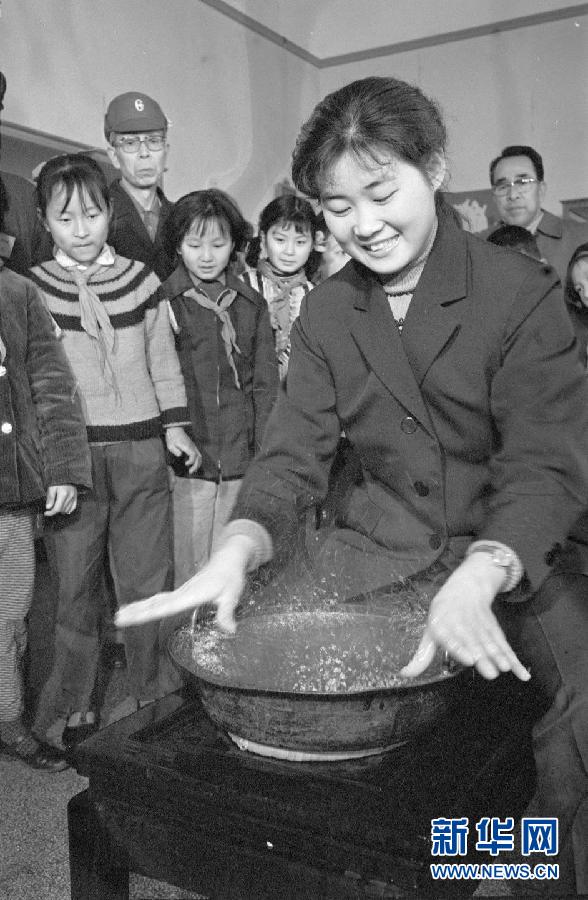 A lady presents the function of a copper washbasin that can spray water when its handles are pressed at Jiangxi History Museum. Photo taken in 1980. 