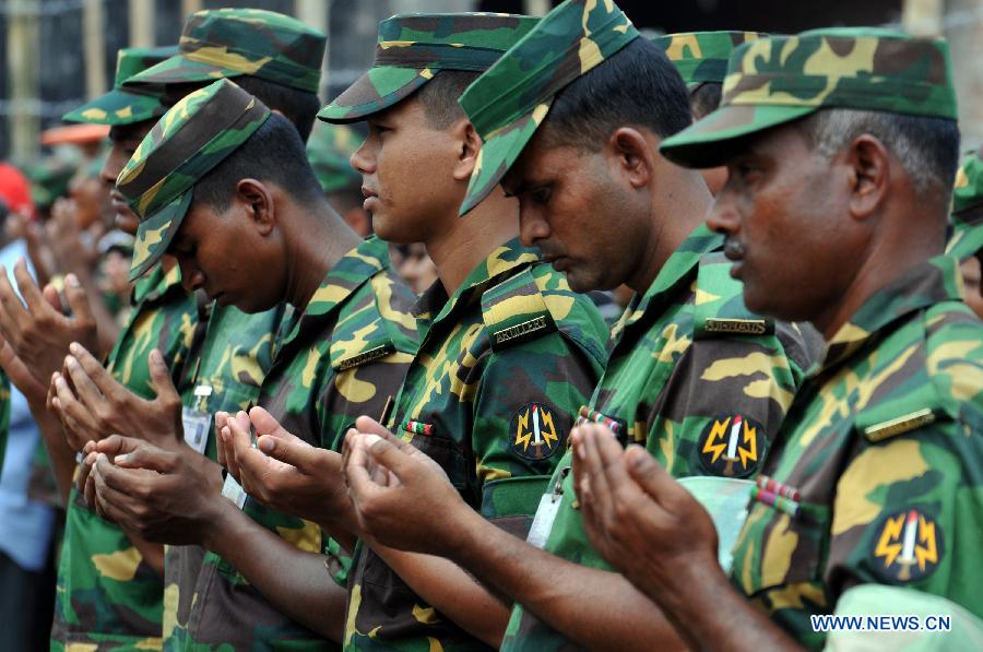 Army personnel take part in a pray for victims of collapsed Rana Plaza building in Savar on the outskirts of Dhaka, Bangladesh, May 14, 2013. Twenty days into the collapse of the building when the confirmed death toll stands at 1,127, the rescuers wrapped up their recovery operations Tuesday morning. (Xinhua/Shariful Islam)