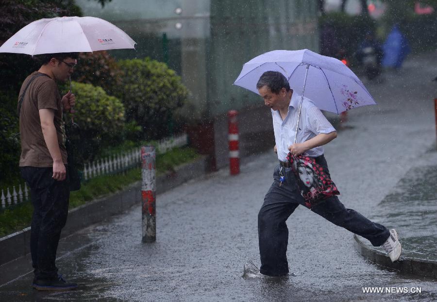 Citizens walk in rain on a waterlogged road in Nanchang, capital of east China's Jiangxi Province, May 15, 2013. A heavy rainfall hit Nanchang overnight. (Xinhua/Zhou Mi) 