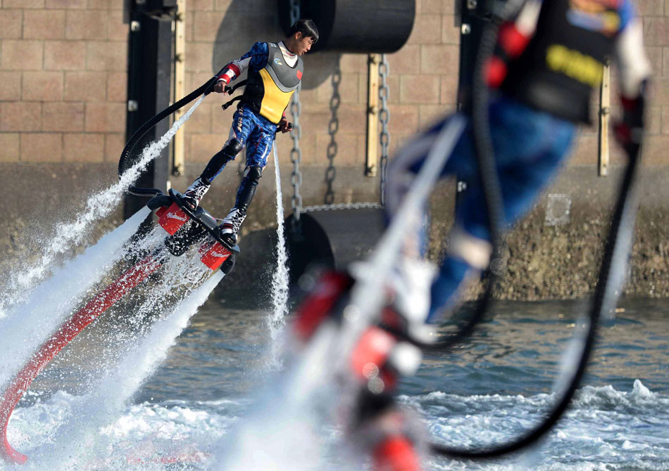 Two men use jetpacks which are propelled by jets of water to fly over the sea, east Chinese city Qingdao, May 5, 2013. (Xinhua/Li Ziheng)