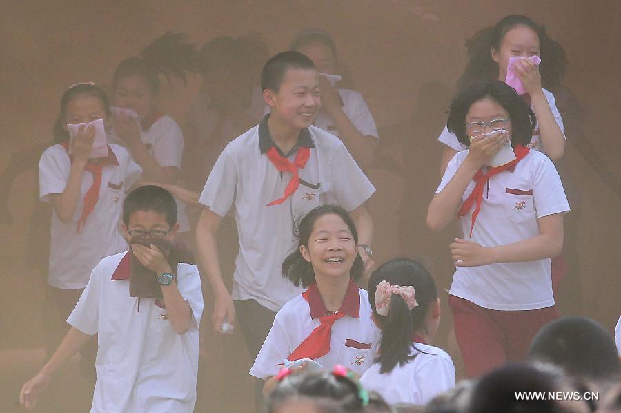 Pupils evacuate during an earthquake drill at the Fendou Elementary School in Beijing, capital of China, May 15, 2013. (Xinhua/Li Wen) 