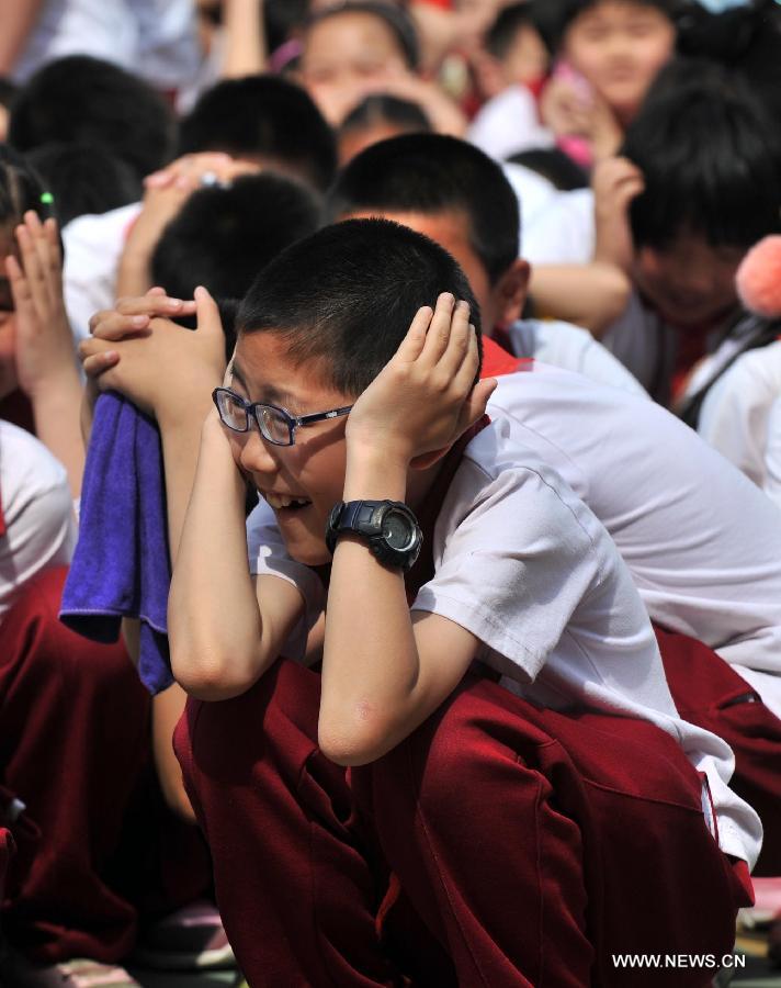 Pupils take part in an earthquake drill at the Fendou Elementary School in Beijing, capital of China, May 15, 2013. (Xinhua/Li Wen) 