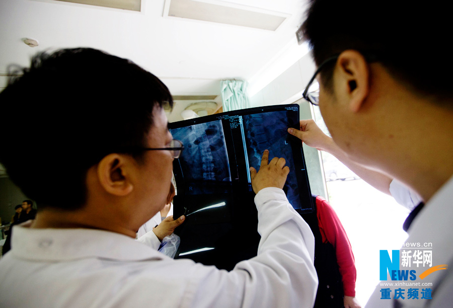 Doctors examines the x-ray film to work out treatment plan.(Xinhua/Peng Bo)
