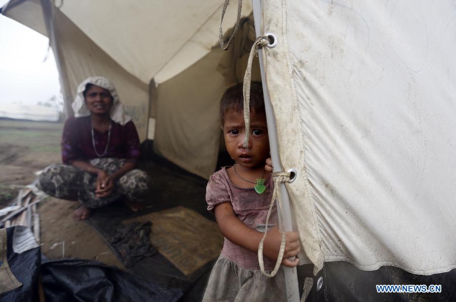 A Bengali-Muslim girl stands in front of her relief tent at Ohndaw Internally Displaced Persons (IDP) camp near Sittway township in Myanmar's western Rakhine coastal area, on May 15, 2013. The Bengali-Muslims will be evacuated to safer places in wake of possible strike on the country by severe cyclonic storm Mahasen. (Xinhua/U Aung)