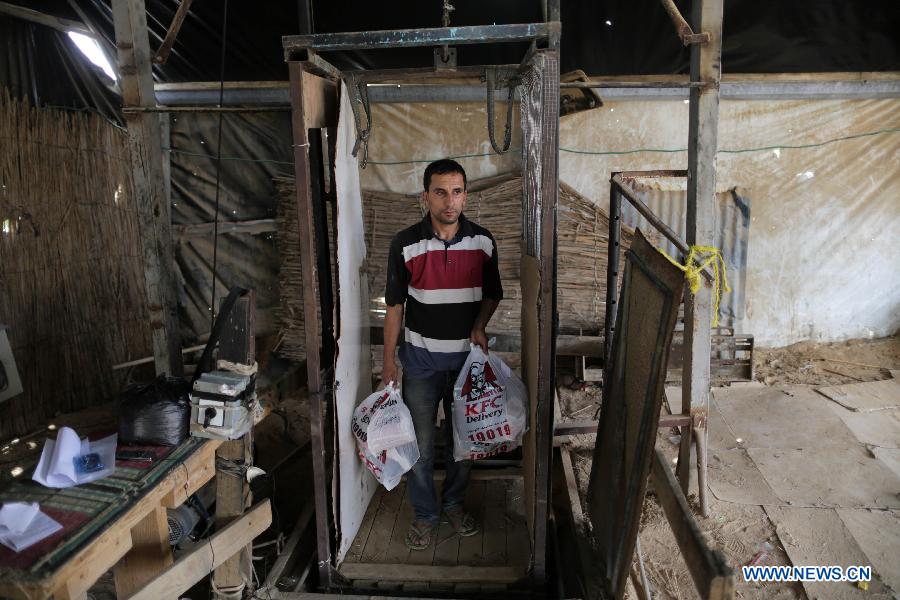 A man comes up from the underground tunnel beneath the Gaza-Egypt border with KFC food in the southern Gaza Strip city of Rafah on May 15, 2013. Ordering fast food from one of the world's most popular restaurants KFC has become possible in Gaza after Al-Yamama delivery company started to bring the food from the Egyptian north Sinai, which borders Gaza. (Xinhua/Wissam Nassar) 