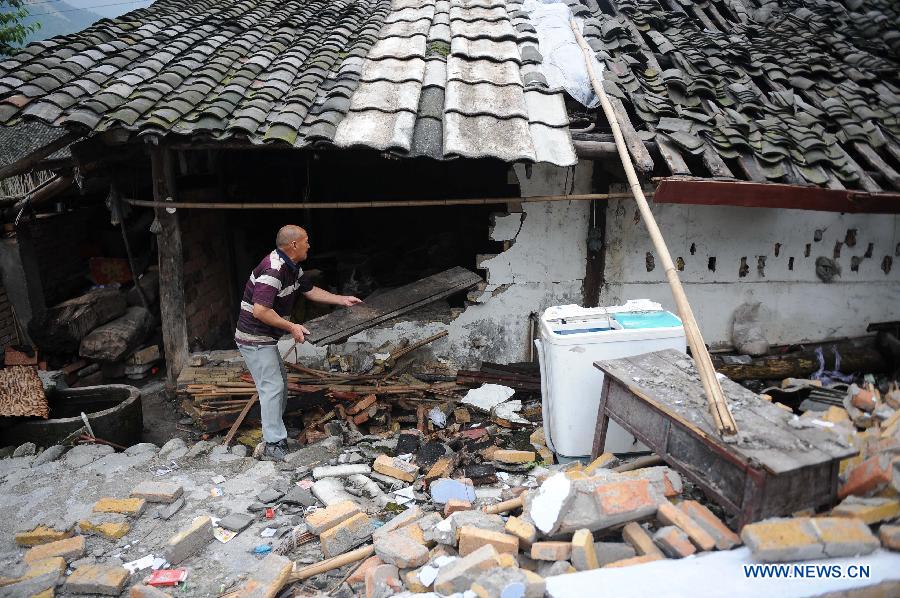 A man sorts out articles from his damaged house at Yuxi Village of Baosheng Township in Lushan County, southwest China's Sichuan Province, May 15, 2013. People in Lushan County are trying to reconstruct their homes and start a new life after the 7.0-magnitude earthquake hit the county on April 20. (Xinhua/Cui Xinyu)