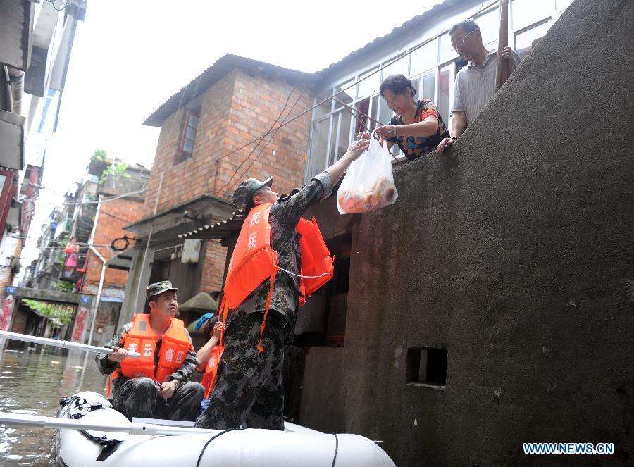 Rescuers send food to the stranded residents on the old Jingshan Street, Nanchang City, capital of east China's Jiangxi Province, May 14, 2013. A heavy rainfall hit Jiangxi Province on May 14. The average rainfall of the province reached 46.4 millimeters, with that of Nanchang climbing to the highest of 71 millimeters May 15. (Xinhua/Yuan Zheng)